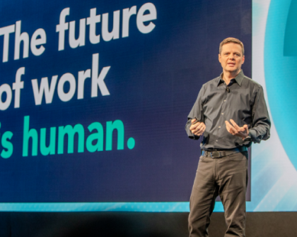 Eric Mosley stands on stage delivering a presentation with the text 